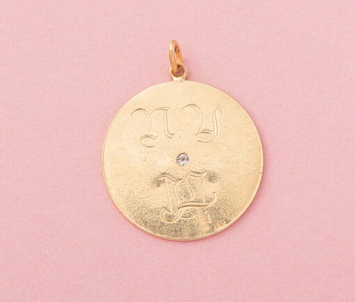 Een 14 karaat gouden bedel met een margriet waaromheen in de rand de tekst 'let me count the ways how do i love you', Amerikaans, circa 1960. gewicht: 8.80 gram afmetingen: 3.8 x 3 cm
