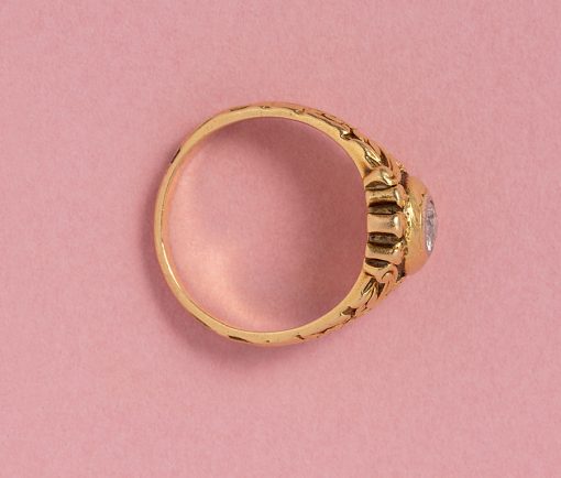 This 18-carat gold ring features an old-cut diamond (app. 0.25 carat) secured in a substantial, white gold bezel setting. The ring's shank is intricately decorated with floral and ribbon motifs. France, circa 1920, numbered: 5721. We see clover, roses, forget-me-nots – please let us know what you see! weight: 8.17 grams ring size: 17.75 mm / 7.5 US