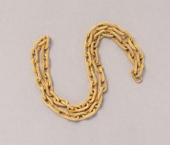 An 18 carat gold set consisting of a bracelet and a chain that can be worn together as a long chain with large oval links of wovern gold with invisible locks, both signed: Hermès Paris, circa 1970.