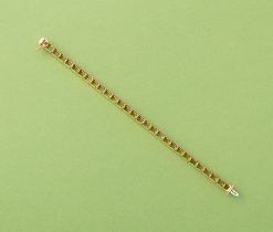 An 18 carat yellow gold tennis bracelet set with a baguette cut peridots (app. 1.25 carat per stone and app. 36.25 carat in total), signed: Tiffany & Co. USA. weight: 21.26 grams length: 17.7 cm width: 0.5 cm