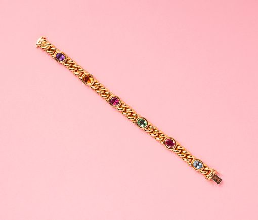 18 carat gold curb link bracelet set with oval facetted gemstone