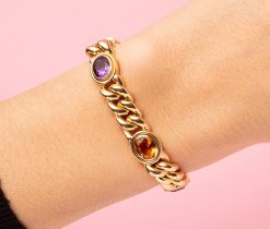 18 carat gold curb link bracelet set with oval facetted gemstone