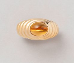 Een 18 karaat geelgouden ring met horizontale ribbels met een ovalencabochon geslepen citrien. Gesigneerd: Bulgari, Italië. gewicht: 9.9 gram ringmaat: 16.25 mm / 5.5 US