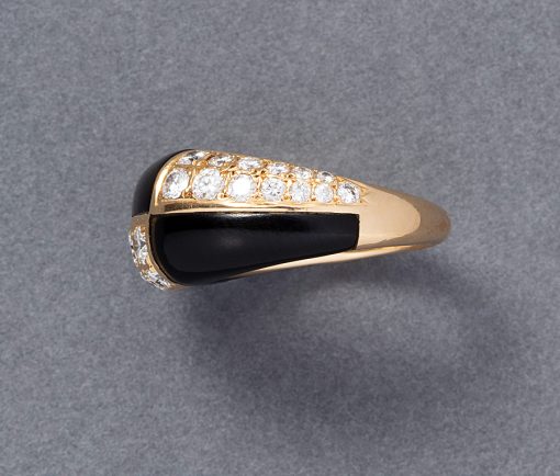 Een 18 karaat geelgouden bombé ring met een vlakverdeling waarvan 3 vlakken ingelegd met zwart onyx en drie vlakken met briljant geslepen diamanten (0.95 ct in totaal). Gesigneerd en genummerd: Van Cleef & Arpels, C504 1X 13. gewicht: 6.2 gram ringmaat: 15.25 mm / 4.5 US / 48