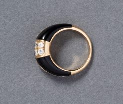 Een 18 karaat geelgouden bombé ring met een vlakverdeling waarvan 3 vlakken ingelegd met zwart onyx en drie vlakken met briljant geslepen diamanten (0.95 ct in totaal). Gesigneerd en genummerd: Van Cleef & Arpels, C504 1X 13. gewicht: 6.2 gram ringmaat: 15.25 mm / 4.5 US / 48