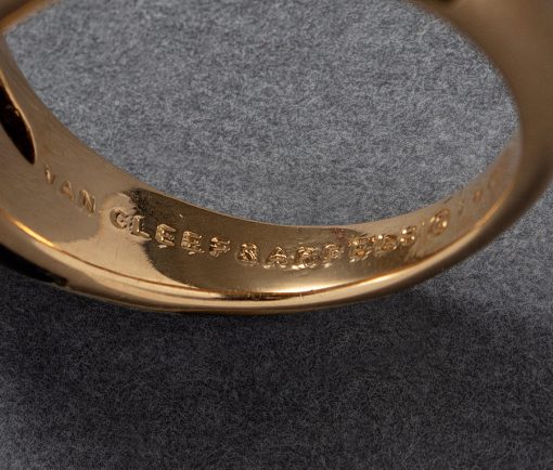 Een 18 karaat geelgouden bombé ring met een vlakverdeling waarvan 3 vlakken ingelegd met zwart onyx en drie vlakken met briljant geslepen diamanten (0.95 ct in totaal). Gesigneerd en genummerd: Van Cleef & Arpels, C504 1X 13. gewicht: 6.2 gram ringmaat: 15.25 mm / 4.5 US / 48