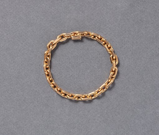 Een 18-karaats geelgouden schakelarmband met half ronde en half gefacetterde links, meesterteken voor Rollang & fils (met name voor Hermes gewerkt), Frankrijk, circa 1970. gewicht: 34.6 g lengte: 18 cm width: 6.5 mm