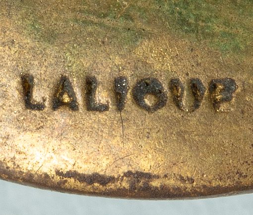 The 'Trois Marguerites'  brooch with a light green circular stained relief foiled glass cast depicting marguerittes mounted in gilt metal, signed and with Maker's mark 'LALIQUE' to the metal mount for René Lalique, circa 1912. Literature reference: F. Marcilhac, 1983, no. 1372.