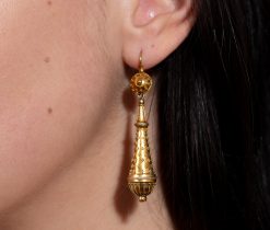 Een paar 18-karaats geelgouden Victoriaanse torpedo oorbellen in neo-Etruskische stijl, rijk gedecoreerd met granuleringen. Europa, circa 1870. gewicht: 3.58 g lengte: 6 cm