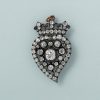 A (onder 14 karaat) rose gold and silver brooch se with a crowned witch heart set in silver, with old-cut diamonds (circa 4 ct, centre diamond circa 1 ct). Circa 1900. weight: 9.2 g measurements: 38 x 25 mm The brooch often with an open heart, and the tail end pointing to the right, is also called a ‘witch heart’ and has been a symbol of love, loyalty and protection since the 15th century.