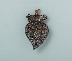 A (onder 14 karaat) rose gold and silver brooch se with a crowned witch heart set in silver, with old-cut diamonds (circa 4 ct, centre diamond circa 1 ct). Circa 1900. weight: 9.2 g measurements: 38 x 25 mm The brooch often with an open heart, and the tail end pointing to the right, is also called a ‘witch heart’ and has been a symbol of love, loyalty and protection since the 15th century.