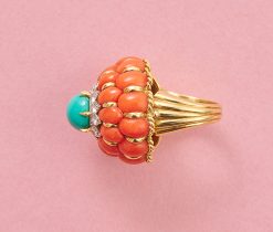 An 18k yellow gold cake ring with two rows of 12 oval cabochon-cut corals around it. The bottom row has slightly larger corals and a gold border between the corals. On top is a white gold flower set with twelve brilliant-cut diamonds, topped with a round cabochon cut turquoise set in six yellow gold claws. At the bottom of the ring is a border of twisted gold wire and two gold balls on the shank, which consists of five bands tapering from wide to narrow, numbered: 2553, circa 1960. weight: 27 g ring size: 16+ mm / 5 1/2 US dimensions: 27.2 (ring width) x 24 (height) mm shank width: 4.2 - 12 mm