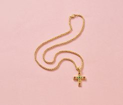 Een 18-karaats gouden kruishanger bezet met saffier, robijn en smaragden, gesigneerd, genummerd en gedateerd: Cartier, model Byzantine aan een gewoven Cartier-ketting. Gewicht: 16 g Afmetingen: 3 cm Lengte ketting: 42 cm
