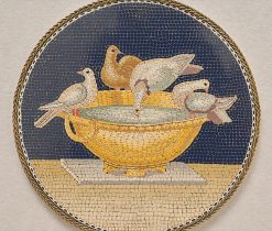 Een micromozaïek gemaakt van minuscule glas draden (tesserae) in verschillende vormen en kleuren, waarmee de voorstelling als het ware is geschilderd. Het mozaïek stelt de duifjes van Plinius, toegeschreven aan het atelier van Giacomo Raffaelli, vervaardigd rond 1800 in Rome in een latere zilveren montage. De Vaticaanse mozaïek studio’s waren al in 1576 om de schilderijen in de Sint Pieter te vervangen door mozaïek, maar in de 18e eeuw ontstond er een ware rage en werd het Romeinse mozaïek zowel als kunstwerk als souvenir zeer populair. Aanleiding hiervoor was de vondst van een vloer fragment van mozaïek; de duifjes van Plinius, het meest geliefde en bekendste mozaïek uit de oudheid. Kardinaal Giuseppe Furietti (1685 – 1764) vond het fragment tijdens het opgraven van de Villa Adriana in Tivoli in 1737. Volgens Furietti was dit fragment het originele Griekse fragment door Sosos van Pergamon waar Plinius de oudere over heeft geschreven. Plinius roemt dit mozaïek als de perfecte kunst. Hij schrijft: “Er is een prachtige duif aan het drinken en de schaduw van zijn hoofdje wordt gereflecteerd in het water, de andere duiven wassen zich en zonnen op de rand van de schaal”. Hoewel Furietti’s fragment nu wellicht als een kopie voor Keizer Hadrianus wordt gezien, werd het in 1764 door Paus Clemens XIII gekocht en naar het Capitolijns museum gebracht, waar duizenden bezoekers het nu dagelijks bewonderen. Dit vroeg 19e eeuwse micromozaïek is een zeer fijne en gedetailleerde kopie van de duifjes uit het Capitool. gewicht: 45 g diameter: 7.5 cm literatuur : voir Domenico PETOCHI, I m osaici minuti Romani del secoli XVIII-XIXe siècle, page 108, n°29.