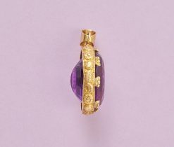 Een 18k gouden hanger, bezet met een grote ovale, gefacetteerde amethist, waarop de tekst „Exemplo Meo Tibi Semper” is gegraveerd, circa 1910. gewicht: 15.84 g afmetingen: 4.7 x 2.8 cm