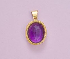 Een 18k gouden hanger, bezet met een grote ovale, gefacetteerde amethist, waarop de tekst „Exemplo Meo Tibi Semper” is gegraveerd, circa 1910. gewicht: 15.84 g afmetingen: 4.7 x 2.8 cm