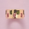 Een 18-karaats gouden ring bezet met 16 baguette geslepen groene en roze toermalijnen (ca. 4.35 crt), Duits, circa 2020. gewicht: 8 g ringmaat: 17.75 mm / 7.5 (US) / 55.5 breedte: 1 cm