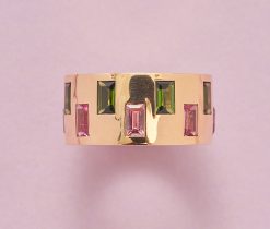 Een 18-karaats gouden ring bezet met 16 baguette geslepen groene en roze toermalijnen (ca. 4.35 crt), Duits, circa 2020. gewicht: 8 g ringmaat: 17.75 mm / 7.5 (US) / 55.5 breedte: 1 cm