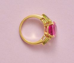 Een 18-karaats gouden ring, bezet met een ovale roze toermalijn (ca. 5,70 ct, 13,4 x 11 x 6,8 mm), met aan weerszijde een peer geslepen peridot (ca. 2,50 ct). meeterteken: kruis in een cirkel. B. Frankrijk. gewicht: 8.3 g ringmaat: 16.75 mm / 6 1/4 US / 52 mm