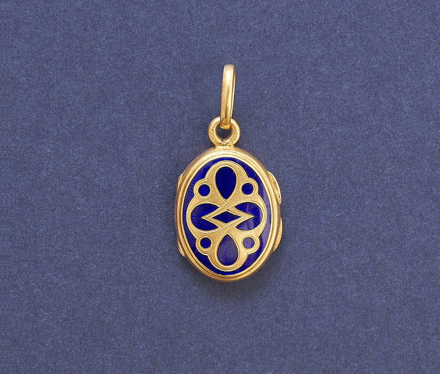 Een 18-karaats geelgouden medaillon versierd met donkerblauwe emaille over een guilloche. met een compartiment, Frankrijk, circa 1900. gewicht: 5.02 g afmetingen: 3 x 1.5 cm