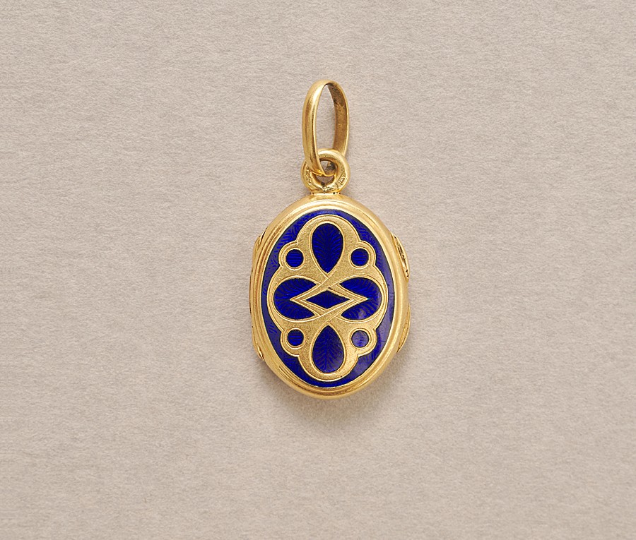 Een 18-karaats geelgouden medaillon versierd met donkerblauwe emaille over een guilloche. met een compartiment, Frankrijk, circa 1900. gewicht: 5.02 g afmetingen: 3 x 1.5 cm