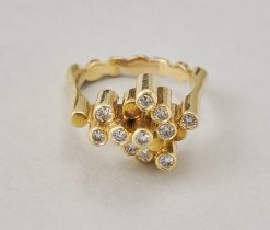 Een 18-karaats geelgouden torenring met in elf torentjes briljant geslepen diamanten gezet. Frankrijk, circa 1970. gewicht: 8.5 g ringmaat: 16.5 - mm / 6 US / 53 mm breedte: 2.5 - 12 mm