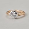 Een 18-karaats gouden bi-color solitair ring bezet met een brillant geslepen diamant (circa 1.1 ct, 6.6 - 6.4 x 3.6 mm, G, Si1 - Vvs op het oog maar met een filled fracture) gladomzet met witgoud, Frankrijk. gewicht: 7.3 g afmetingen: 9 x 9 x 5 mm ringmaat: 17 mm / 6.5 US / 53