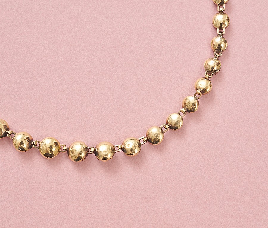 Een 18-karaats rosé gouden collier bezet met 40 ronde roosgeslepen granaten gezet op rood goud folie aflopend in grootte, Zuid-Frankrijk, circa 1900. gewicht: 19.95 g lengte: 39 cm