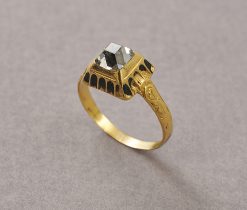 Een Renaissance ring van 19-karaat geel goud bezet met een tafel geslepen diamant (app. 0.9 crt G / Piq) in een hoge, gedecoreerde "doos" zetting met zwarte email in de gegraveerde boogjes, de scheen floraal gegraveerd, vroeg 17e eeuw. gewicht: 9.6 g ringmaat: 18.25 mm 8 US / 57 breedte: 1.8 - 8.5 mm afmetingen: 9.6 x 10.7 x 6.7 mm De resultaten van het metallurgisch onderzoek door CIRAM adhv ICP en SEM op het goud zijn bekend: - 19 karaat goud - geen tekenen van moderne toevoegingen in de legering (zoals cadmium, dat doorgaans in modern goud wordt aangetroffen) - natuurlijke verweringsfasen aan het oppervlak die de ouderdom bevestigen.
